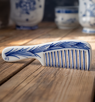 Blue and white ceramic comb on a wooden surface.